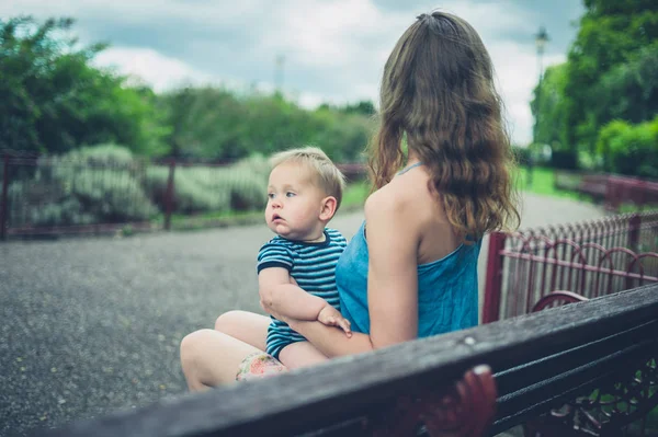 Anne ile bebek parkta bankta — Stok fotoğraf