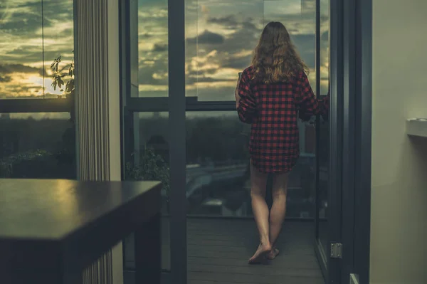 Mulher na blacony admirando o nascer do sol — Fotografia de Stock