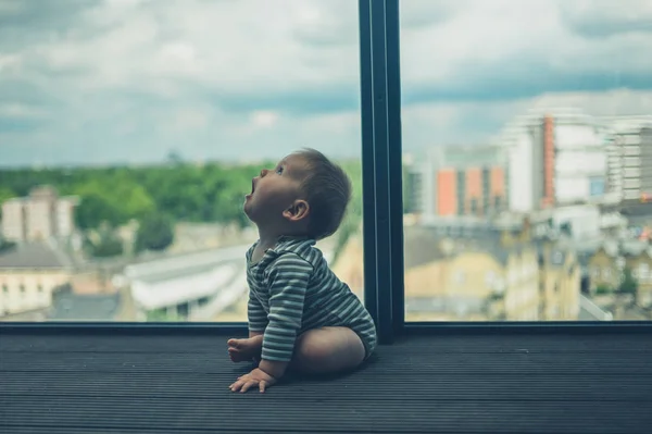 Lilla bebis sitter på balkong i staden — Stockfoto
