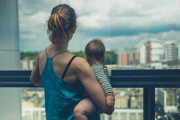 Madre con bebé en el balcón de la ciudad —  Fotos de Stock