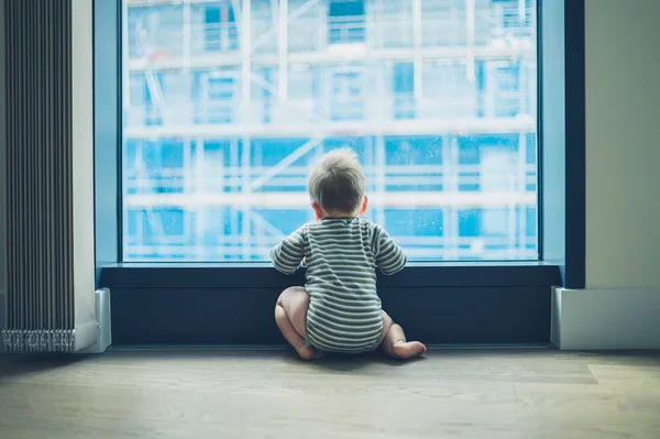 Lilla bebis genom fönstret i höghus Lägenhet — Stockfoto