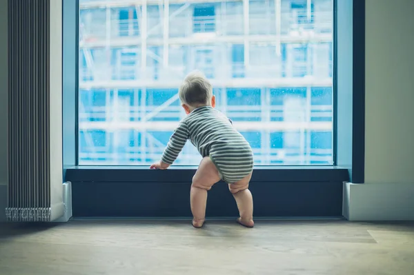 Lilla bebis genom fönstret i höghus Lägenhet — Stockfoto