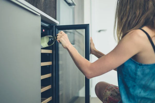 Frau holt Flasche Wein aus Kühlschrank — Stockfoto