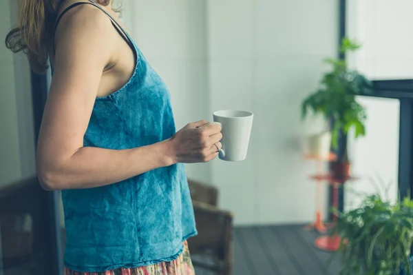 在阳台的妇女与杯子咖啡 — 图库照片