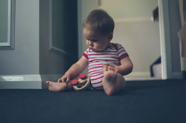 Pequeno bebê brincando no chão em casa — Fotografia de Stock