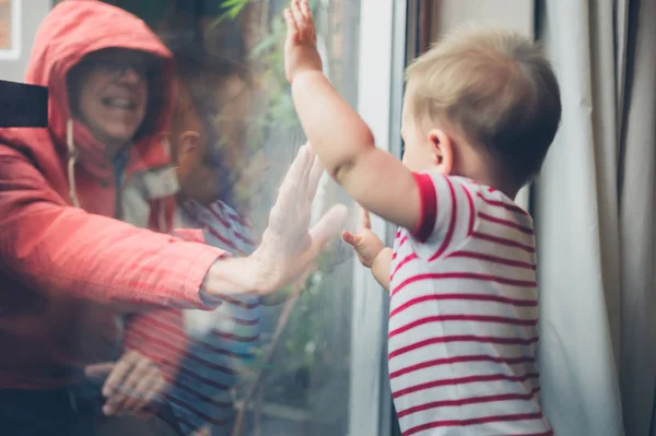 Дедушка играет с внуком у окна — стоковое фото