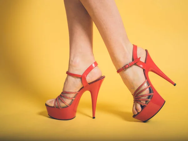 Woman in red stripper heels on yellow — Stock Photo, Image