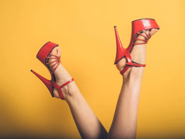 Kvinna med röd strippa klackar i luften — Stockfoto