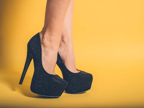 Sexy pernas de mulher vestindo saltos pretos — Fotografia de Stock
