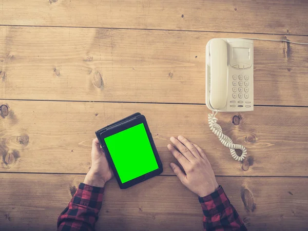 Uomo a tavola con tablet e vecchio telefono — Foto Stock