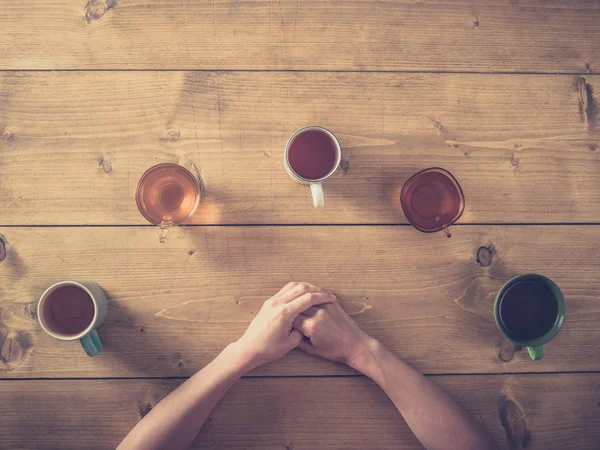 Mulher à mesa com xícaras de chá — Fotografia de Stock