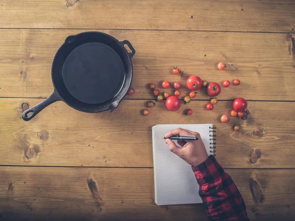 Sobre vista de homem escrevendo receita para tomates fritos — Fotografia de Stock