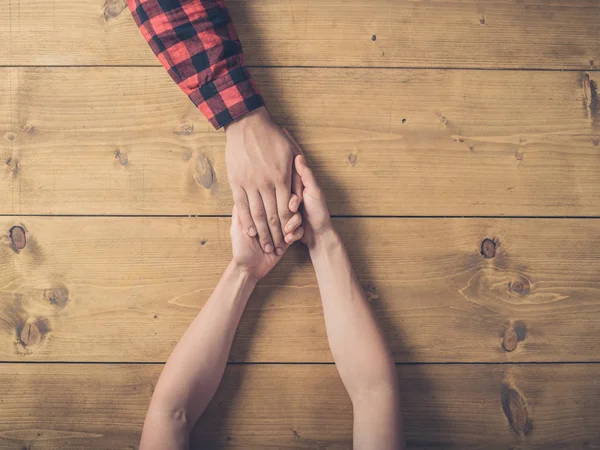 Weergave van man en vrouw hand in hand op tafel — Stockfoto