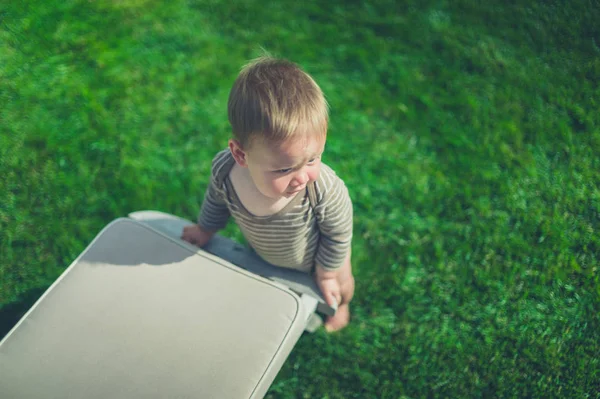 Malé dítě pomocí lehátko postavit se — Stock fotografie