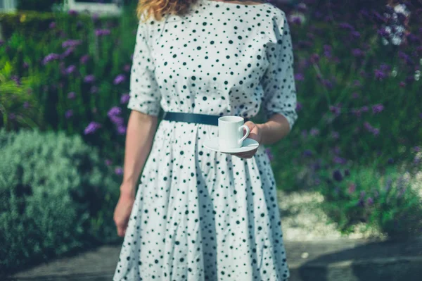 정원에서 커피 한잔과 함께 젊은 여자 — 스톡 사진