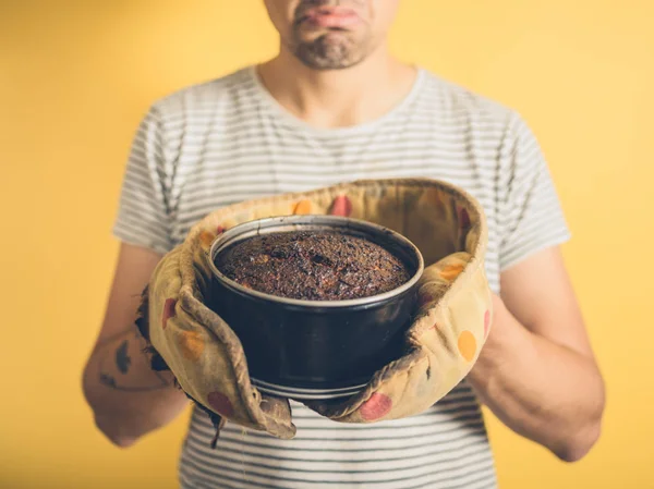 Jeune homme bouleversé avec gâteau brûlé — Photo