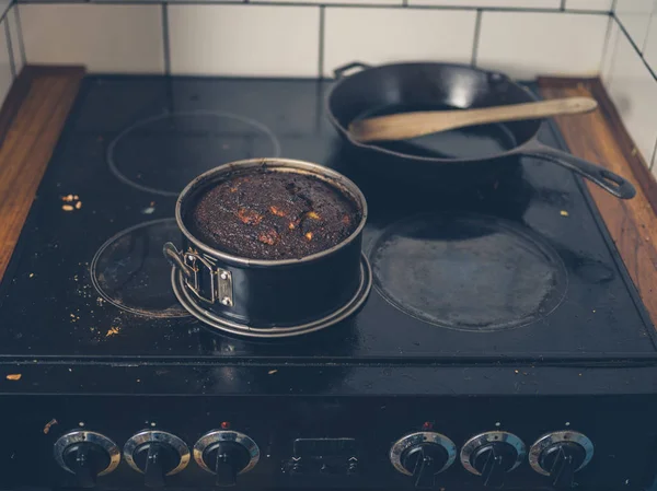 Burnt cake on dirty stove — Stock Photo, Image