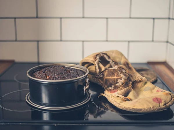 Pastel quemado y guante de horno en la cocina —  Fotos de Stock