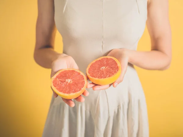 Woman with grapefruit halves — Stock Photo, Image