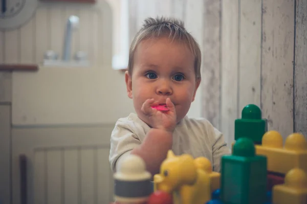 Bebê brincando na cozinha de fingir — Fotografia de Stock