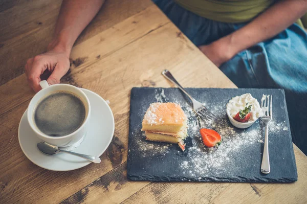 Mulher bebendo café e comendo bolo de esponja — Fotografia de Stock