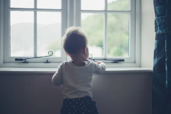 Little baby standing by the window — Stock Photo, Image