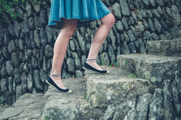 Jambes et pieds de jeune femme montant les marches — Photo