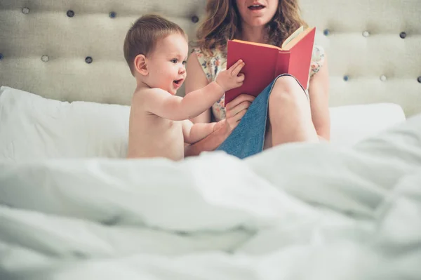 Mutter liest ihrem Baby im Bett vor — Stockfoto