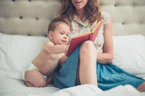 Μητέρα του στο κρεβάτι, διαβάζοντας στο μωρό της — Φωτογραφία Αρχείου