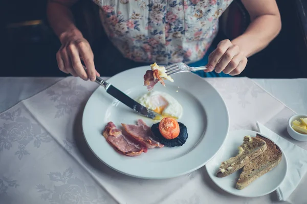 Donna che fa colazione con uova e pancetta — Foto Stock