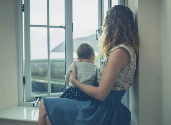 Mor och barn av fönster av lantliga hem — Stockfoto