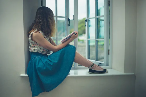 Vrouw leest door raam van het landhuis — Stockfoto