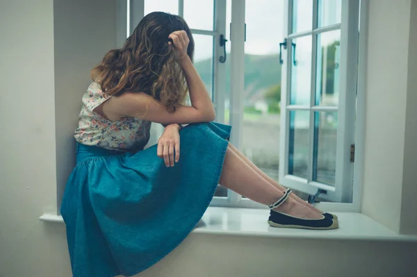 Smutně a zamyšleně žena u okna venkovský dům — Stock fotografie