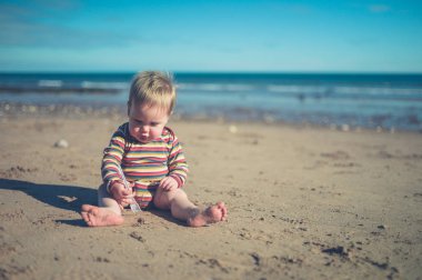 Sahilde oturmuş çocuk