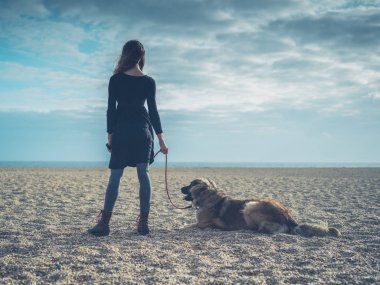 Genç kadın ile dev köpek sahilde