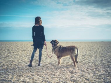 Genç kadın ile dev köpek sahilde