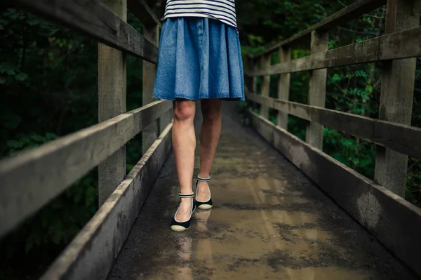 Vrouw op brug in bos — Stockfoto