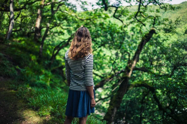 Junge Frau steht im Wald — Stockfoto