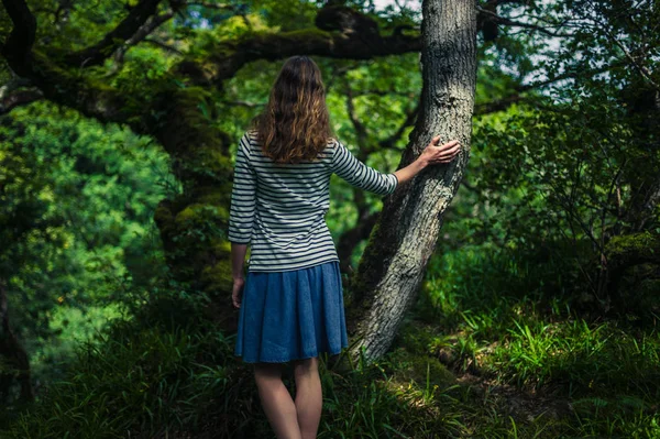 Jonge vrouw lopen in het bos — Stockfoto