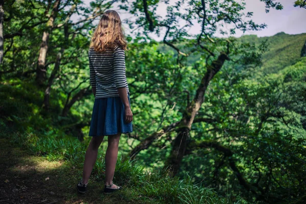 Mujer joven caminando en el bosque — Foto de Stock