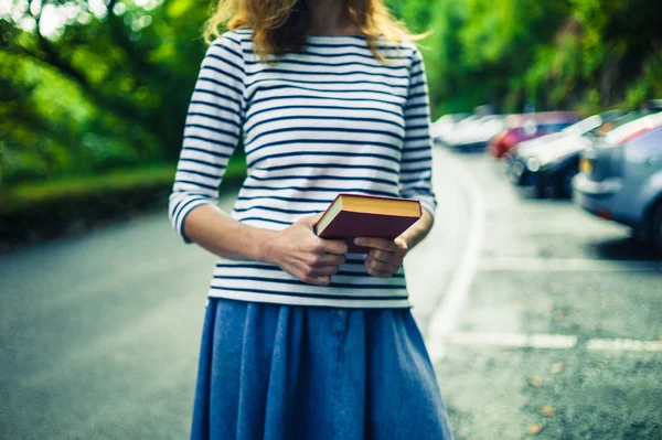 Jonge vrouw met boek in parkeergarage — Stockfoto