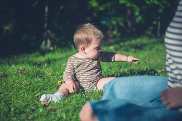 Pequeño bebé jugando en la hierba afuera — Foto de Stock
