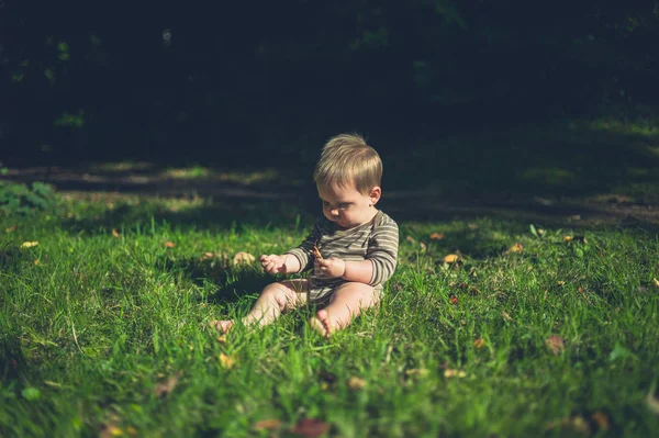 Pequeno bebê brincando na grama lá fora — Fotografia de Stock