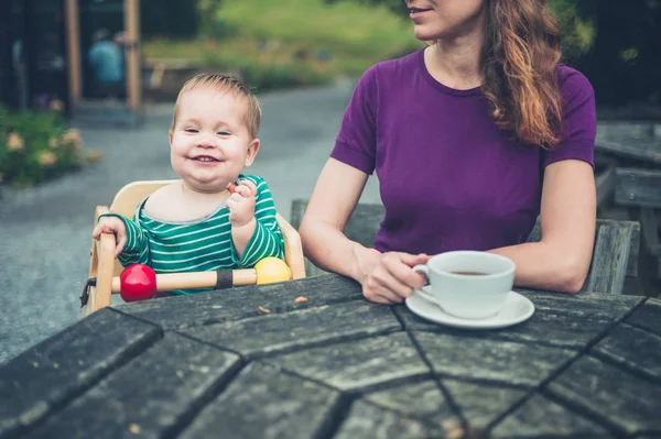母親と赤ちゃんが外のテーブル — ストック写真