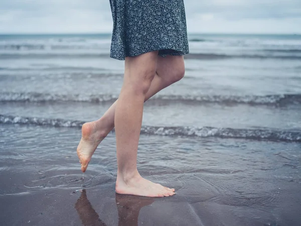 Ung kvinna promenader på stranden — Stockfoto