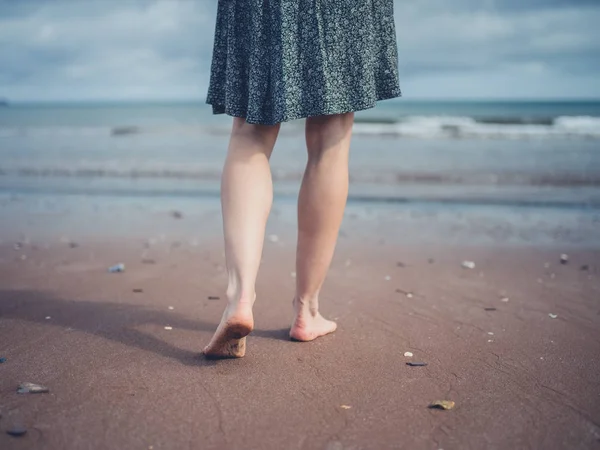 Junge Frau spaziert am Strand — Stockfoto