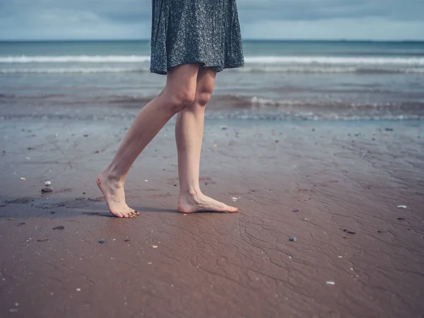 Νεαρή γυναίκα περπατά στην παραλία — Φωτογραφία Αρχείου