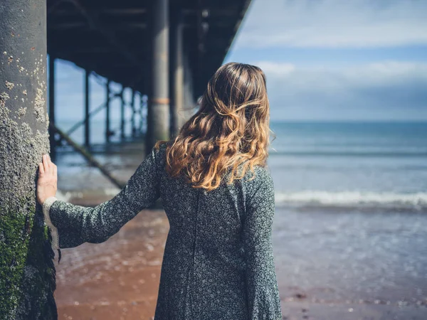 Jonge vrouw stond onder pier — Stockfoto
