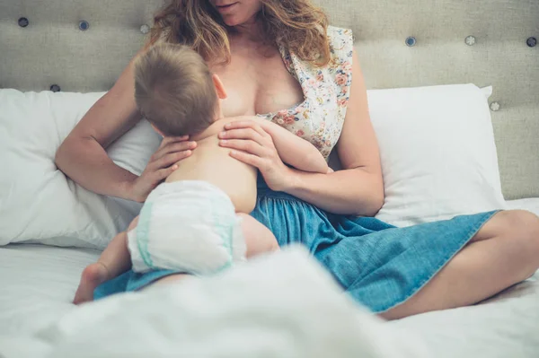 Mamma allattamento al seno bambino a letto — Foto Stock