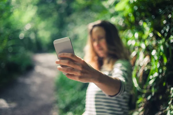 Jonge vrouw selfie te nemen in het bos — Stockfoto